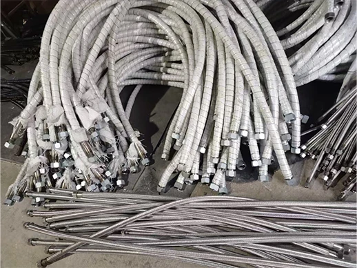 Multiple asbestos-wrapped metal hoses placed on the ground