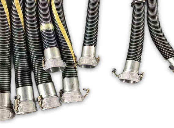 Multiple black fuel oil suction and discharge flexible composite hoses with fittings placed on the ground