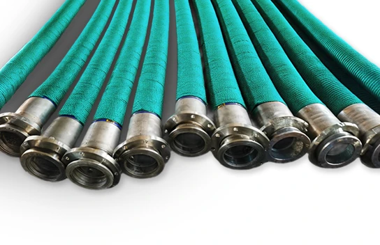 Multiple green fuel oil suction and discharge flexible composite hoses with flange joints are placed on the ground